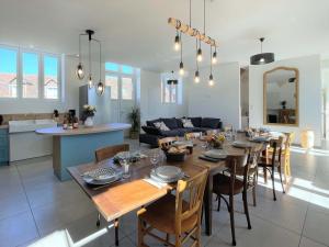 a dining room and living room with a table and chairs at Gîte spacieux dans le Perche avec WIFI inclus, idéal pour réunions familiales - FR-1-497-240 in Val-au-Perche