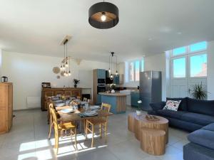 a kitchen and living room with a table and a blue couch at Gîte spacieux dans le Perche avec WIFI inclus, idéal pour réunions familiales - FR-1-497-240 in Val-au-Perche +27 photos