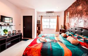 a bedroom with a bed with a colorful blanket on it at DANK Hotel 420 friendly in Patong Beach +33 photos