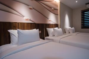 two beds with white pillows in a hotel room at Dai Nam Boutique Hotel in Ho Chi Minh City