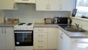 a kitchen with a stove and a sink at Donlan's Delight - steps from Mollymook sands in Mollymook