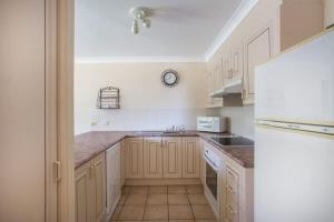 a kitchen with white cabinets and a sink at Birchgrove Collers Beach - pet-friendly apartment in Mollymook