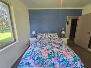 Un dormitorio con una cama con un edredón colorido. en Fathoms 1 - 2BR beach resort apartment, en Mollymook