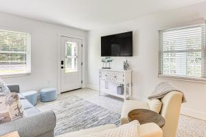 a living room with a couch and a tv at Walk to Crystal River Home with Lanai and Yard! in Crystal River