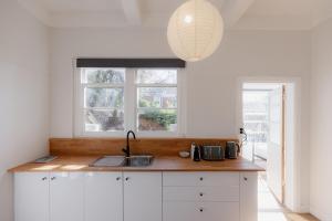 une cuisine avec un évier et une fenêtre dans l'établissement Tamar River Views Mid-Century Vibes, à Royal Park 25 autres photos