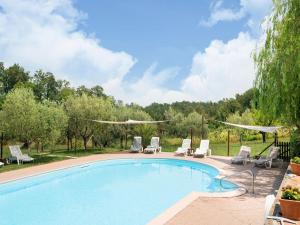 a swimming pool with chaise lounge chairs at Apartment in Tuscany near Pisa and Beaches in Nugola