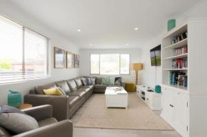 a living room with a couch and a table at Bella Blu Beach House - direct beach access in Vincentia