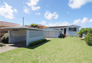 a house with a fence in front of a yard at Bella Blu Beach House - direct beach access in Vincentia