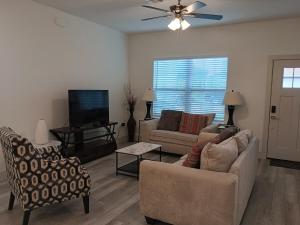 a living room with two couches and a flat screen tv at THE WHOLE HOUSE, QUIET COZY HOME 4 Bed 3 bath in Ocala