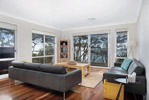 a living room with a couch and a table at Escape to Hyams Beach by Jervis Bay Rentals in Hyams Beach +13 photos