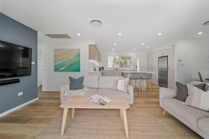 a living room with a couch and a table at Elements of Hyams - perfect Hyams Beach getaway in Hyams Beach