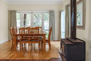 a dining room with a table and a wood stove at Bowen View - pet-friendly home near Hyams Beach in Hyams Beach