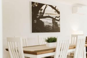 mesa de comedor y sillas con una foto en la pared en Seahaven - pet-friendly retreat near Hyams Beach, en Hyams Beach