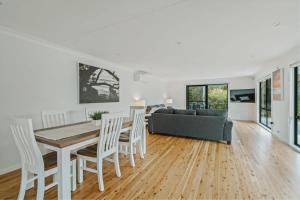 Una sala de estar con una mesa y sillas y un sofá. en Seahaven - pet-friendly retreat near Hyams Beach, en Hyams Beach