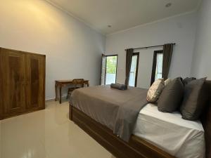 a bedroom with a large bed with pillows on it at Pristine penida in Nusa Penida +2 photos