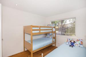 a bunk bed in a room with a window at Harbour Haven - steps from Ulladulla Harbour in Ulladulla