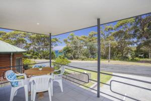 a view from the balcony of a house with a table and chairs at Harbour Haven - steps from Ulladulla Harbour in Ulladulla +4 photos