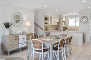 a kitchen and dining room with a table and chairs at Days By The Bay - 3BR house with ocean views in Hyams Beach