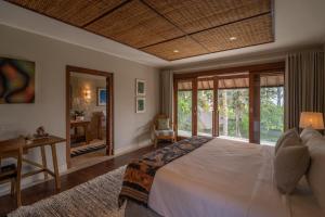 タナロットにあるAsmara Cemagi - Luxury Fully Staffed Villa, Sunset & Beach Near Cangguのベッドと机と窓のある寝室 +43枚の写真