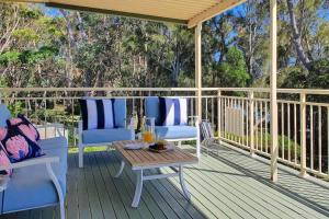 een terras met twee stoelen en een tafel erop bij Pelican Beach House - 50m from inlet & playground in Narrawallee
