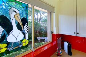 een keuken met een raam met een glas-in-loodraam bij Pelican Beach House - 50m from inlet & playground in Narrawallee +16 foto's