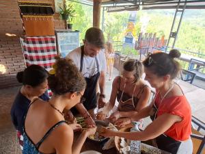 a group of women standing around a table eating food at Umah de Madya The Room & Panoramic Rooftop Munduk in Munduk