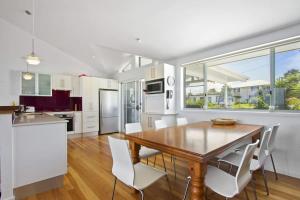a kitchen and dining room with a wooden table and chairs at Sticks by the Sea - pet-friendly coastal home in Manyana +16 photos
