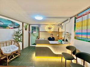 皮皮岛Sweed Dee Love Hostel的一位男士坐在餐厅柜台前