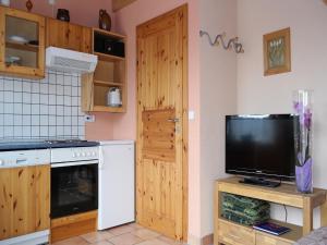ベルガーエンデ・レートヴィッシュにあるFerienhaus mit Sauna und Whirlpoolのテレビ、コンロ、ドアのあるキッチン +31枚の写真