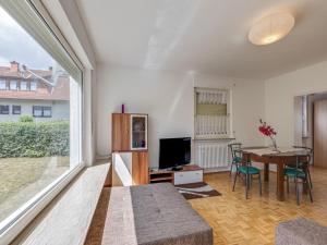 a living room with a table and a large window at Nature Escape in Fuldabruck in Fuldabrück
