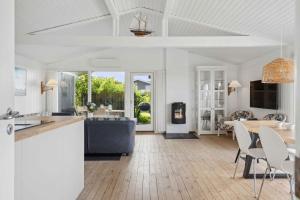 a kitchen and living room with a table and chairs at Lovely Summerhouse By Skaastrup Strand W Sea View in Bogense