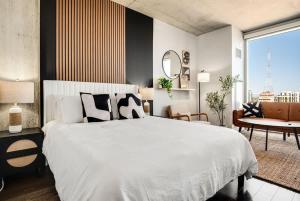 a bedroom with a large white bed and a large window at Boulevard Stays Downtown Highrise STU Sky Pool Parking Gym 05 in Phoenix