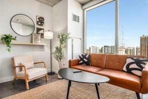 a living room with a couch and a table at Boulevard Stays Downtown Highrise STU Sky Pool Parking Gym 05 in Phoenix +28 photos