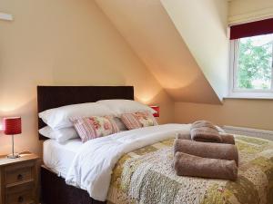 a bedroom with a bed with white sheets and a window at Baswick Steer in Burshill