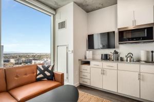 a kitchen with a couch and a large window at Boulevard Stays Downtown Highrise STU Sky Pool Parking Gym 08 in Phoenix