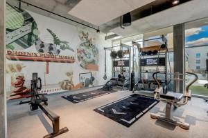 a gym with two tread machines and a wall mural at Boulevard Stays Downtown Highrise STU Sky Pool Parking Gym 08 in Phoenix