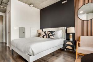 a bedroom with a large white bed and a chair at Boulevard Stays Downtown Highrise STU Sky Pool Parking Gym 08 in Phoenix