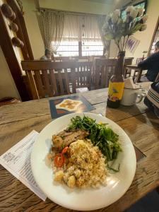 a white plate of food on a wooden table at Hotel Fazenda Portal da Canastra in Zogaias