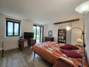 Gîte de charme à Limeuil avec Internet et parking - FR-1-616-497 في Limeuil: غرفة نوم بها سرير كبير وتلفزيون