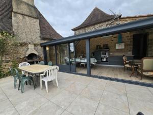 Gîte de charme à Limeuil avec Internet et parking - FR-1-616-497 في Limeuil: فناء مع طاولة وكراسي ومدفأة