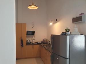 Una cocina con refrigerador de acero inoxidable y microondas. en Cinnamon Holiday Home Near Airport, en Ekala