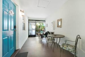 a hallway with a table and chairs and a blue door at Beach Apart By Pmi Unit 2 in West Palm Beach