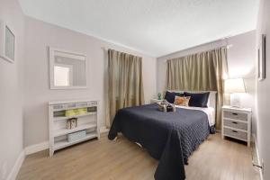 a white bedroom with a bed and a window at Beach Apart By Pmi Unit 2 in West Palm Beach