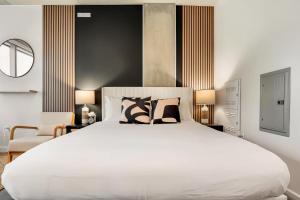 a bedroom with a large white bed with pillows at Boulevard Stays Comfortable Downtown Highrise STU Pool Parking & Gym 10a in Phoenix