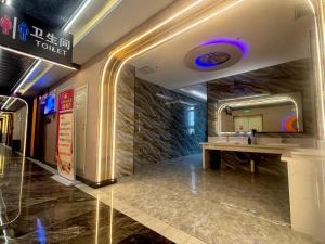 a hotel lobby with a sink and a mirror at 万信至格酒店库车天山中路店 in Kuqa