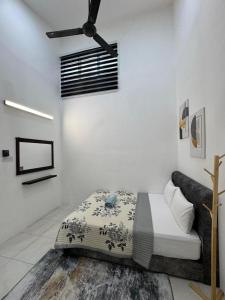 a bedroom with a bed and a ceiling fan at Villa Ammara Homestay in Ipoh +3 photos