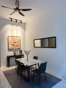 a dining room with a table and a ceiling fan at Villa Ammara Homestay in Ipoh