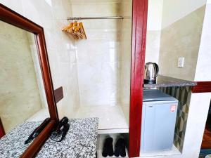 ducha en una habitación con lavabo y espejo en Khách Sạn Hoàng Thanh Thủy 4, en Ho Chi Minh
