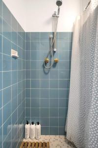 a bathroom with a blue tiled shower with four bottles at Bay Court Iii - Spacious Studio Near Hayes Beach in Sydney +11 photos