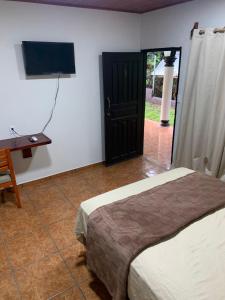 une chambre avec un lit, un bureau et une télévision dans l'établissement Villa Sofia, à San Buenaventura